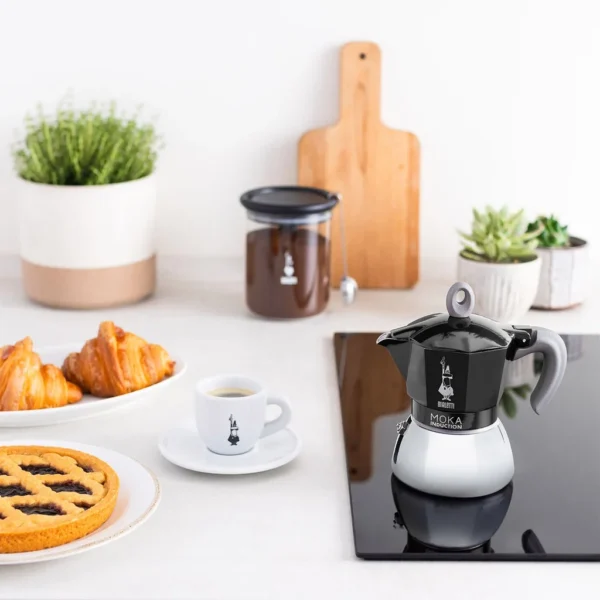 מקינטה ביאלטי מוקה אינדוקציה שחורה 4 כוסות במבט מקרוב, מציגה את גימור האלומיניום והנירוסטה.