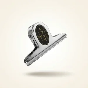 קליפס סוגר לשקיות קפה Bulldog clip מוחזק ביד להמחשת קנה המידה והגודל