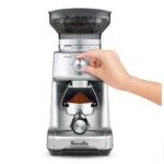 יד מסובבת את חוגת GRIND TIME של מטחנת הקפה Sage Dose Control Pro SCG600 לכוונון זמן הטחינה
