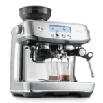 מכונת אספרסו Sage Barista Pro SES878 מוזגת שתי מנות אספרסו, עם צג ה-LCD דולק וזרוע הקיטור בצד
