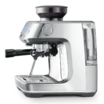 מבט מהצד על מכונת אספרסו Sage Barista Pro SES878, עם מיכל הפולים המלא, ראש החליטה וזרוע הקיטור