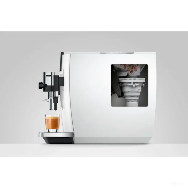מבט מהצד על מכונת קפה Jura E8 Piano White (ED) עם חלון מיכל הפולים ומזיגת אספרסו