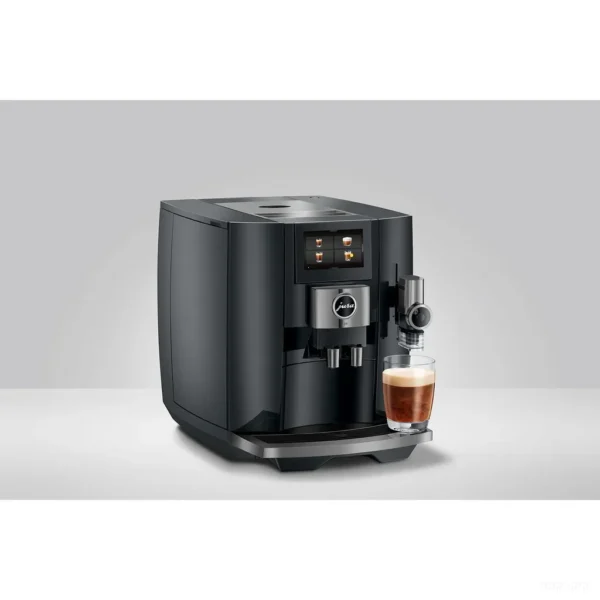 מכונת קפה Jura J10 Piano Black בזווית שלושת רבעי עם כוס משקה חלב מוכנה