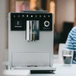 מכונת קפה אוטומטית מליטה Melitta CI Touch Silver על שיש במטבח, המסך הצבעוני מציג בחירת משקה