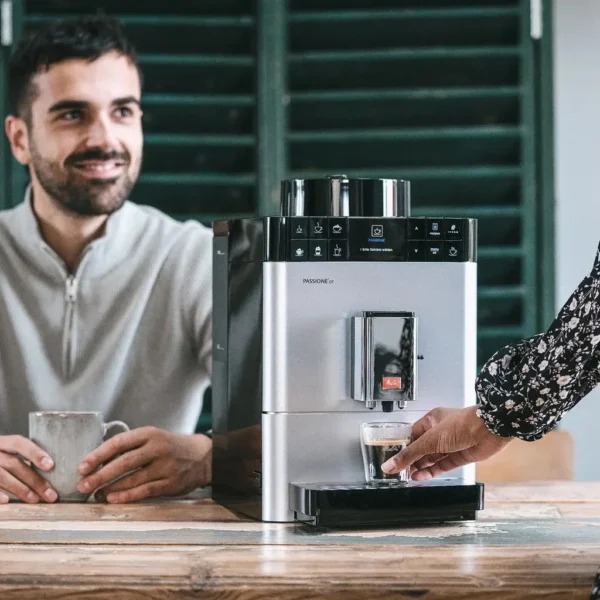 מכונת קפה אוטומטית מליטה Melitta Caffeo Passione OT כסופה על שיש מטבח בזמן מזיגת אספרסו